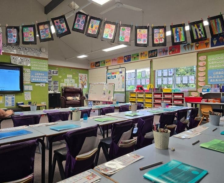 Photo of a classroom in our school featuring artworks and student desks ready for student learning.