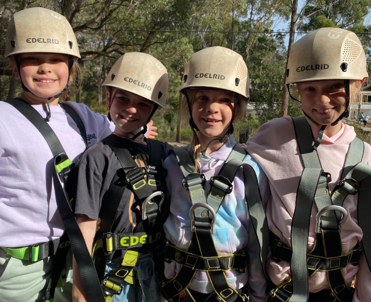 Photo of students at the stage 2 Kianinny Excursion, students are in harnesses and helmets ready for obstacle challenges.