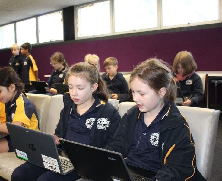 Students in STEM room using laptops.