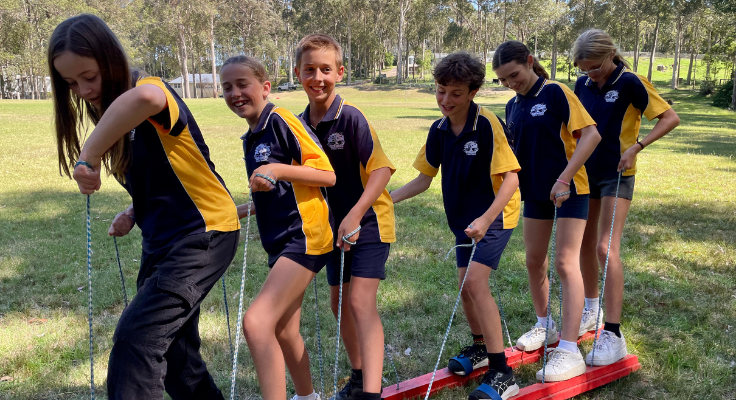Year 6 Students on a leadership excursion, working as a team in a balancing activity.