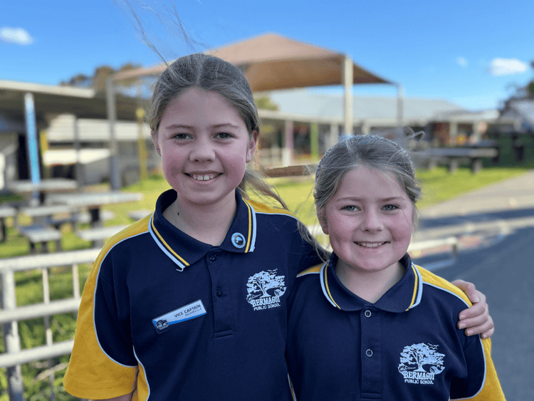 Photo of two students in school uniform in the school playground