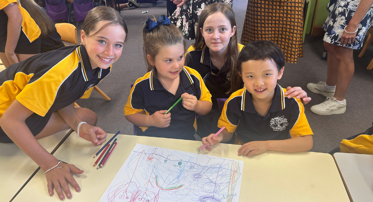 Photo of Year 6 students working with Kindergarten in their classroom