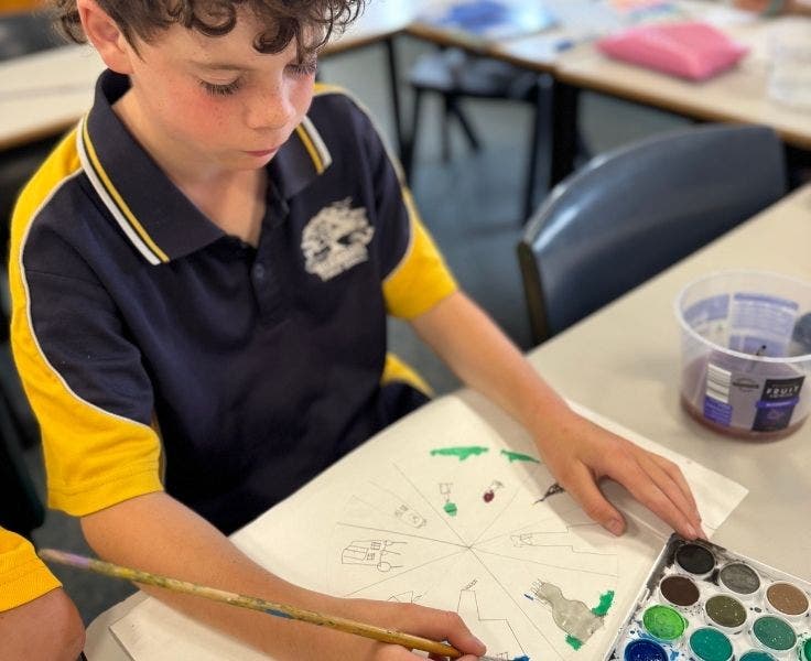 Photo of student in class painting with watercolours