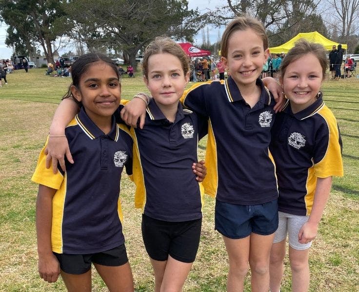 Photo of 4 students in school uniform attending district athletics