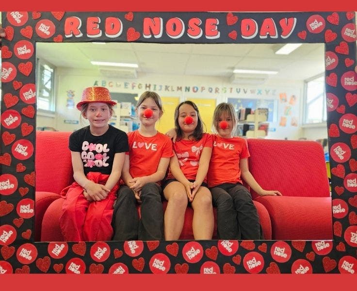 Photo of four students in a frame with the wording red nose day. Students are wearing red and red noses.